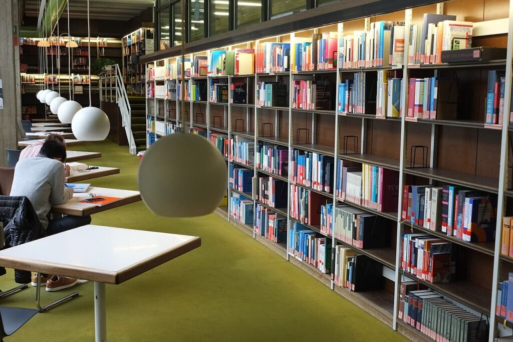 Students working at desks in a university library reading room in Stuttgart, Germany